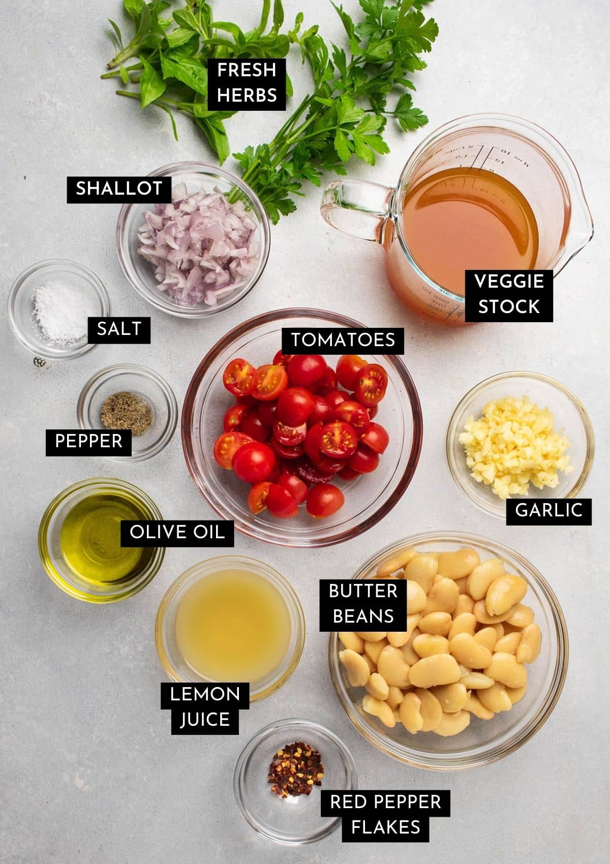 Recipe ingredients, organized into individual glass bowls on a white table.