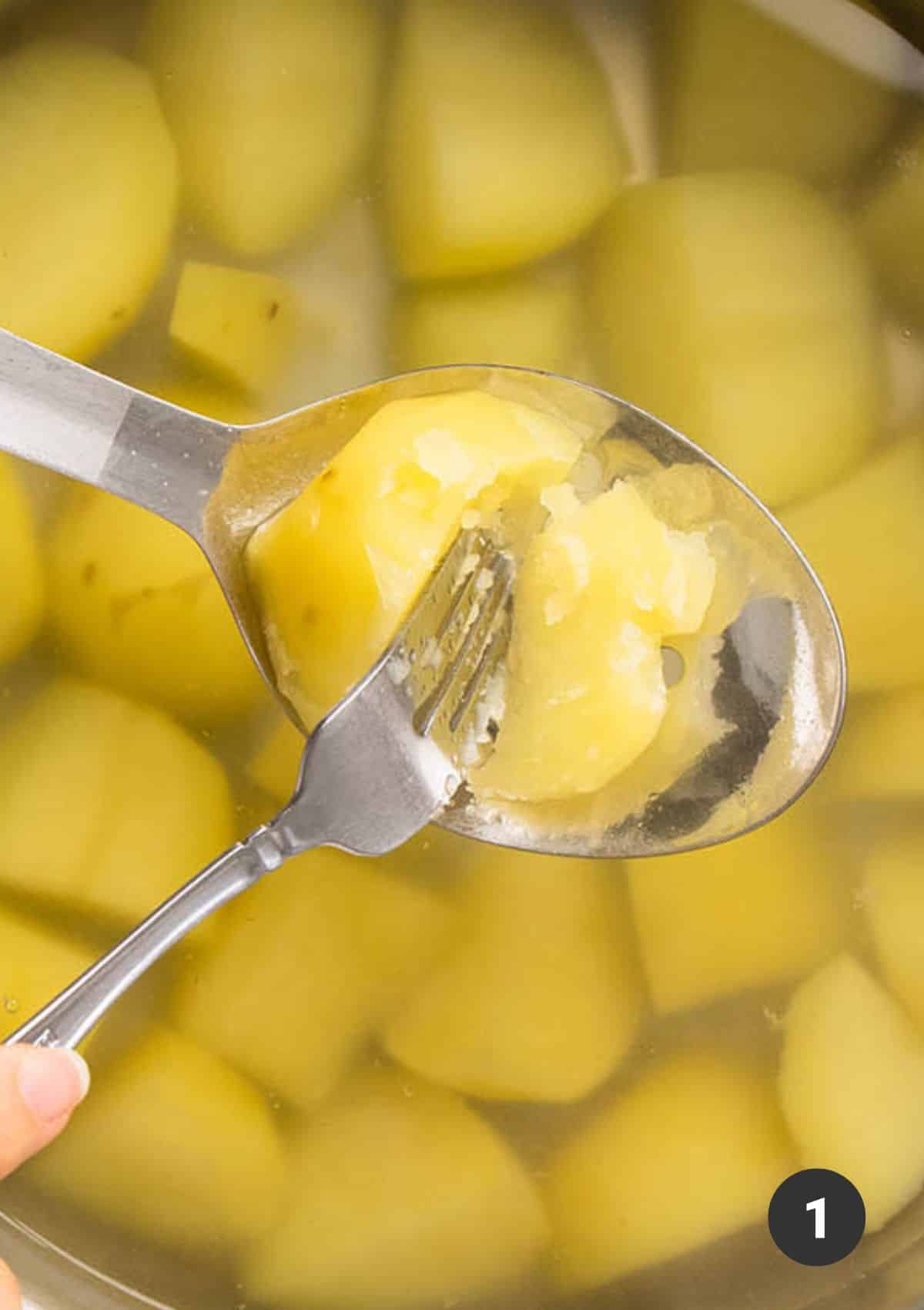 Testing a cooked potato to see if it's easily pierced by a fork.