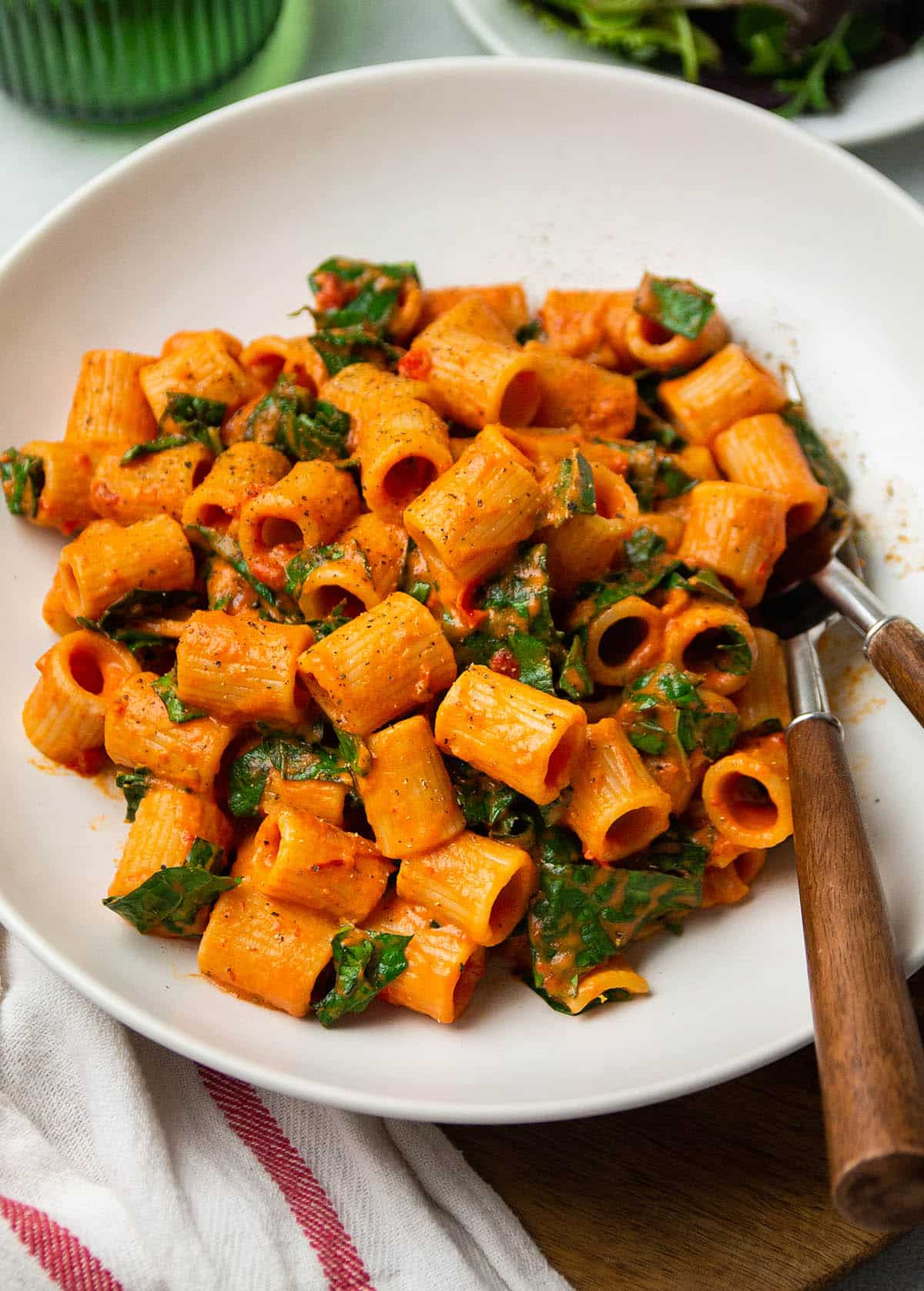 Harissa pasta in a shallow white bowl.