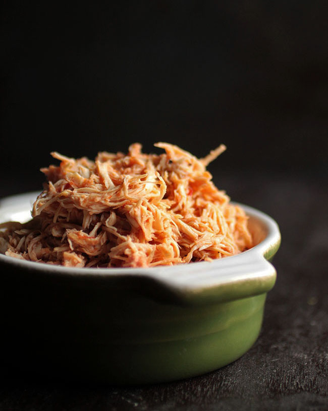 Shredded chicken in a green bowl.