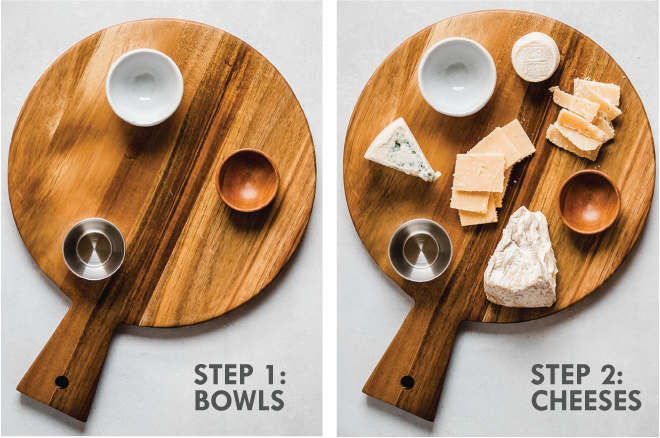 Round wooden board with three small empty bowls and a variety of cheeses. Grey text overlay says \'step 1: bowls, step 2: cheeses.\'