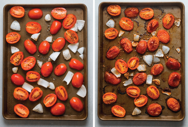 Roma tomatoes and chopped onion being roasted on a large sheet pan.