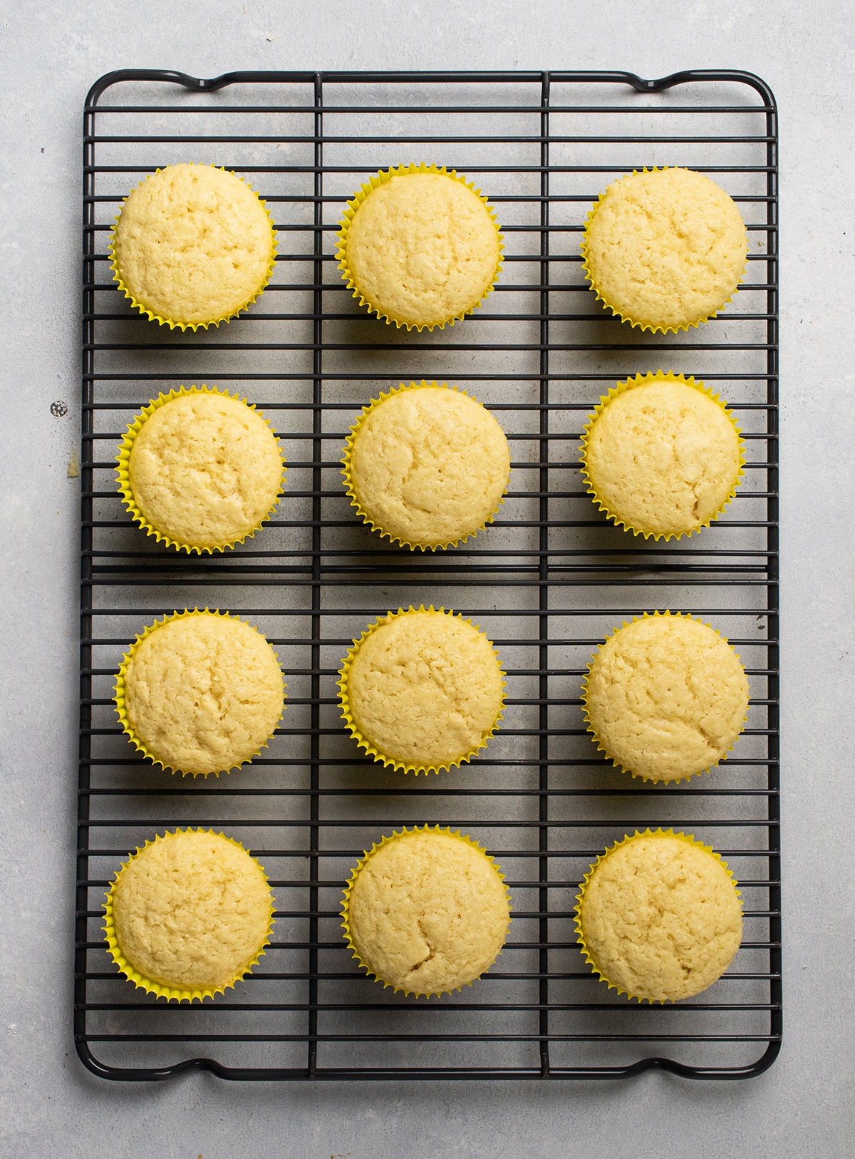 Lemon cupcakes cooling on a wire rack.