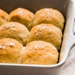 Fresh dinner rolls in a white casserole dish.