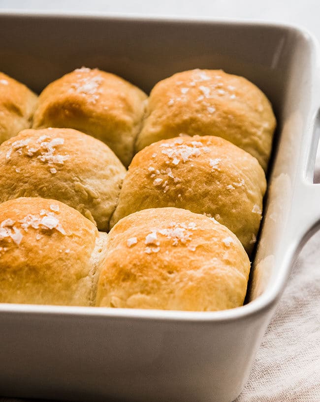 Salted dinner rolls in a white casserole dish.