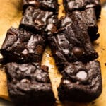 Sliced brownies on a piece of brown parchment paper.