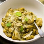 Butter beans in a white bowl with a silver spoon.