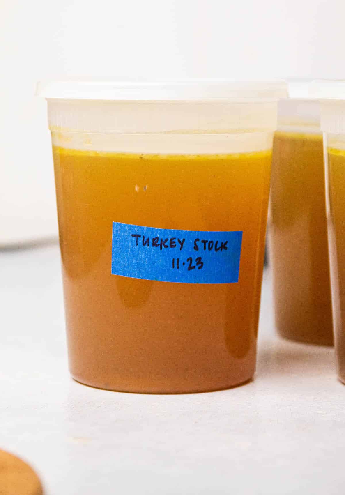 Container of turkey stock with a blue label.